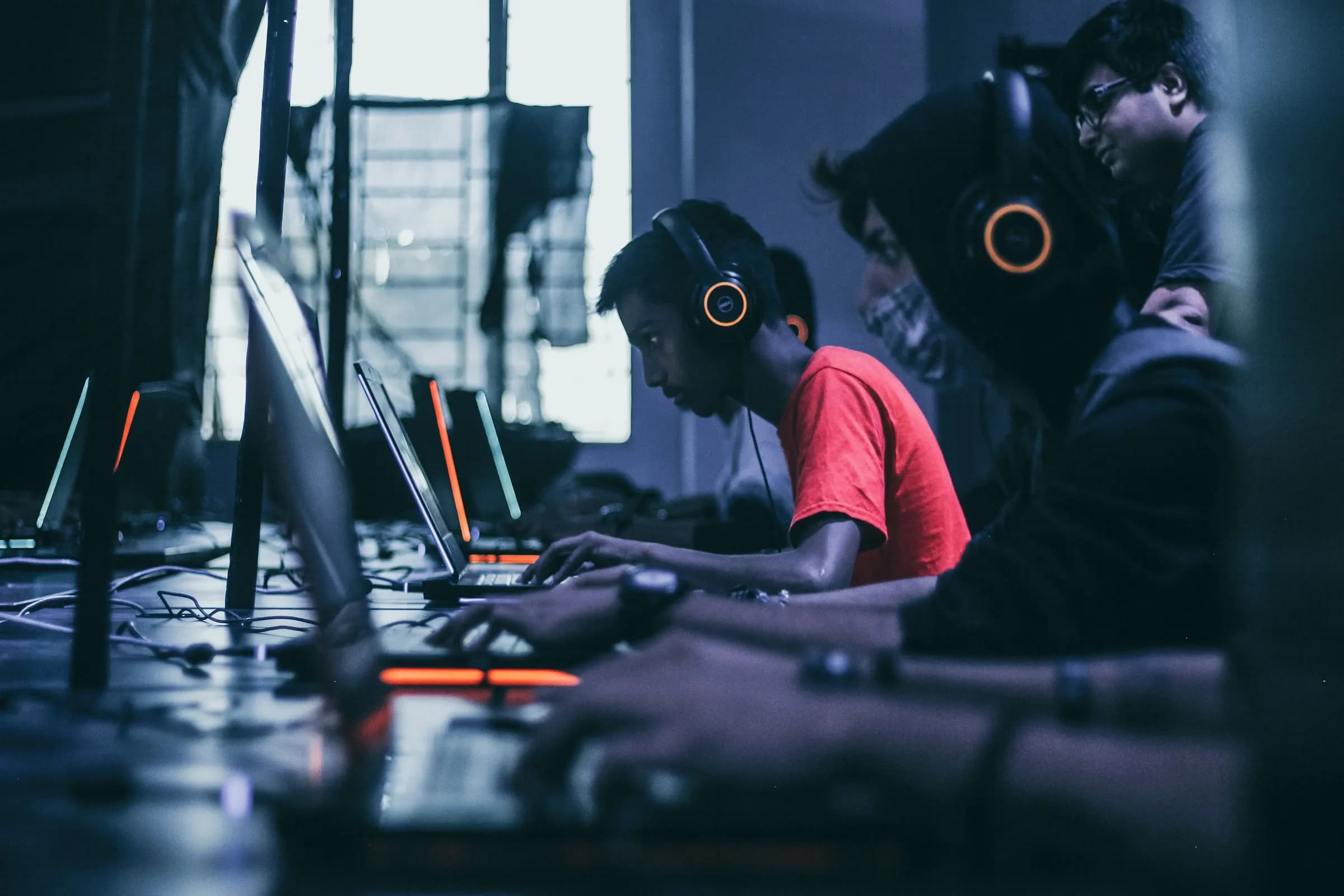 Players wearing headsets competing side by side at a LAN event